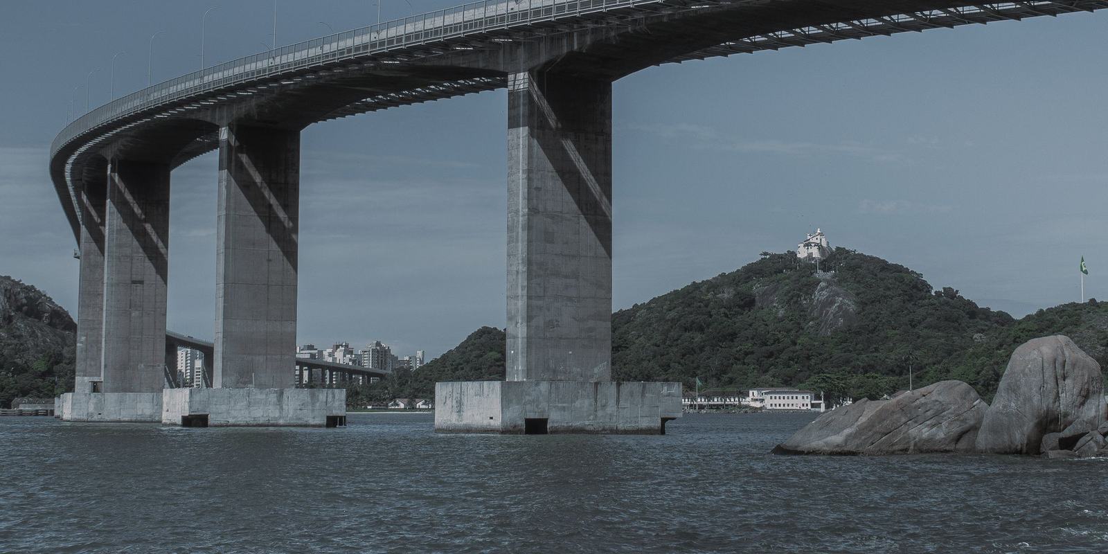 Pilares da Terceira Ponte sobre a baía de Vitória, com o Convento da Penha no alto do morro em Vila Velha